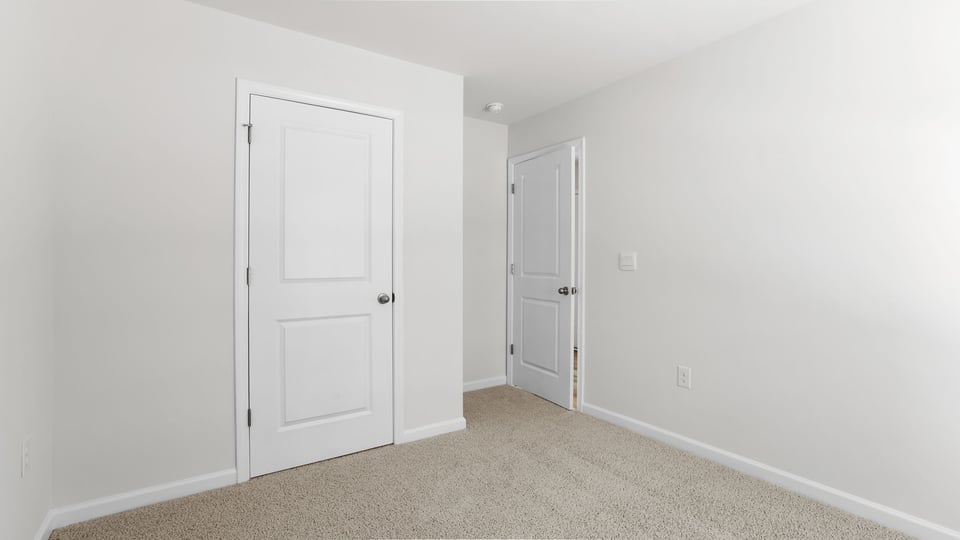 Bedroom with carpet and windows.
