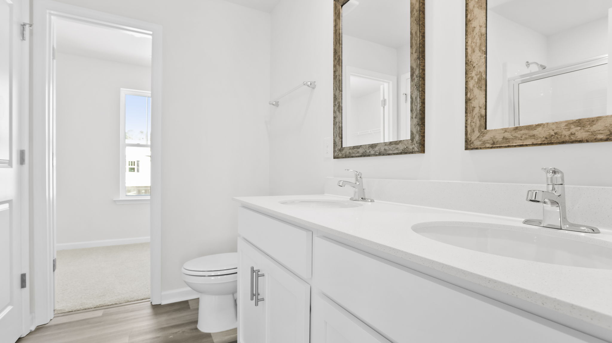 Primary bathroom with dual sink vanity and mirrors.
