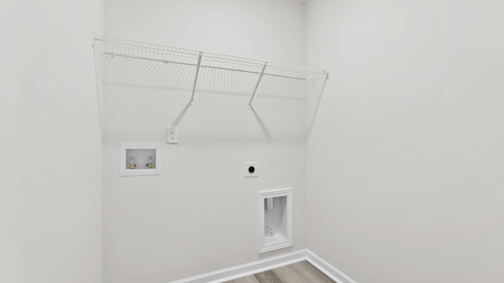 Walk-in laundry room with shelving.