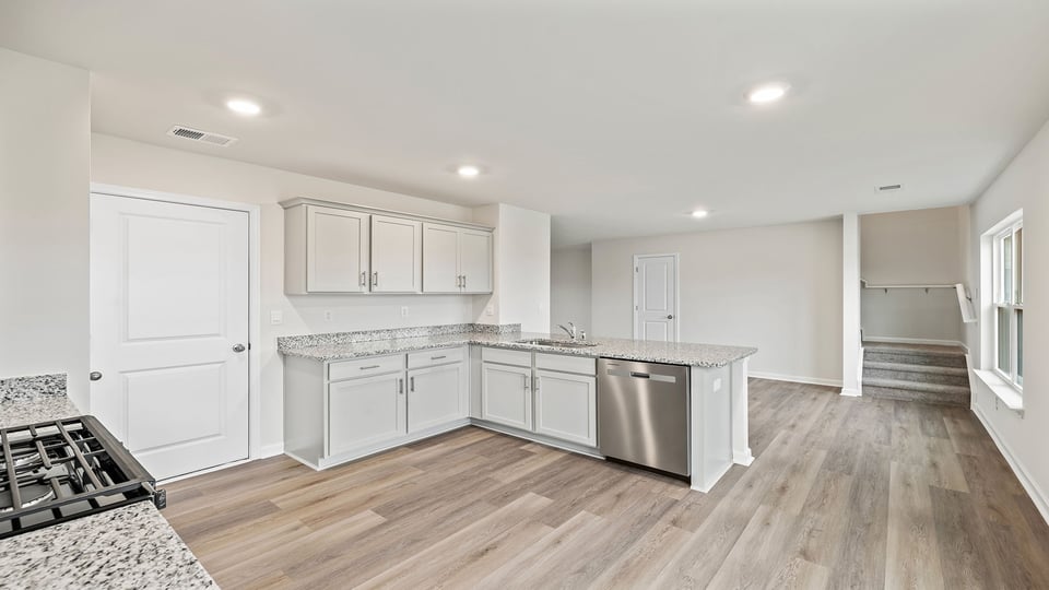 View of the kitchen and dining area, and the stairwell to the upper level.