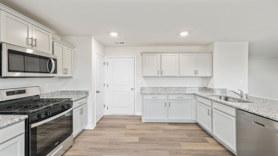 Kitchen features recessed lighting and quartz countertops.