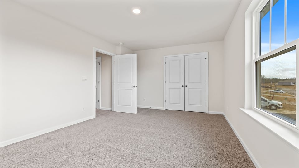 Bedroom with window and carpet.