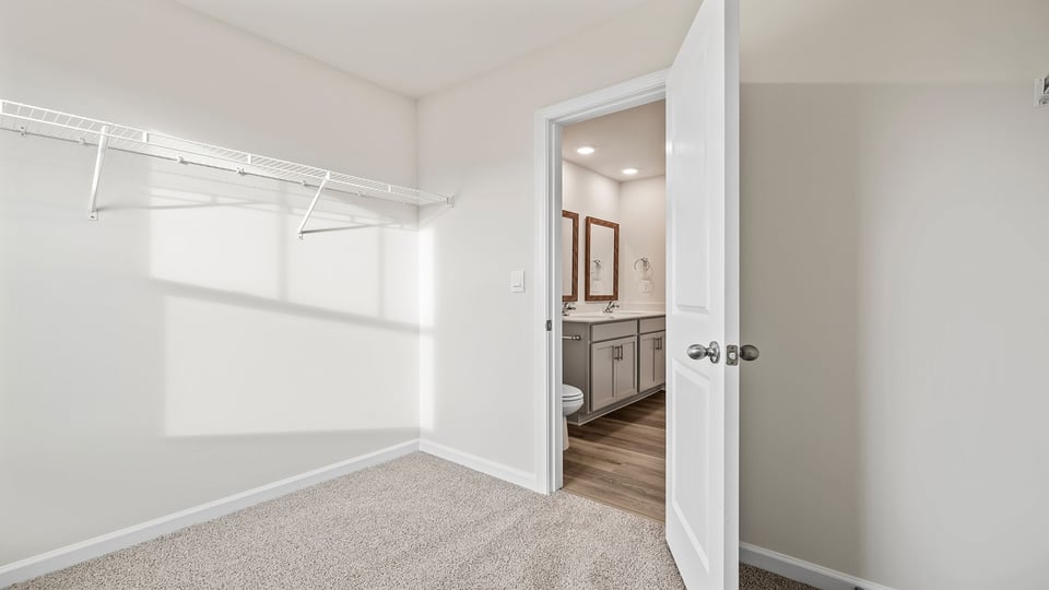 Primary bedroom walk-in closet with window.