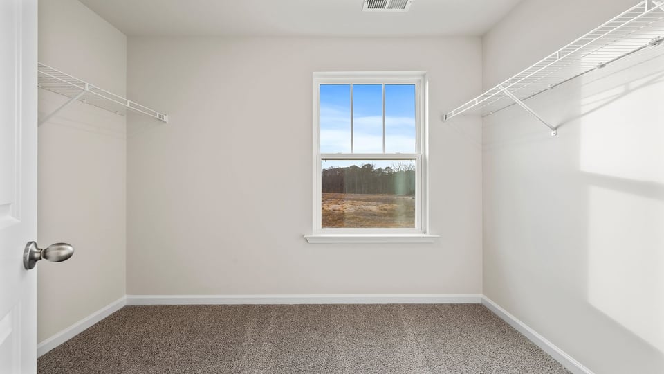 Primary bedroom walk-in closet with window.