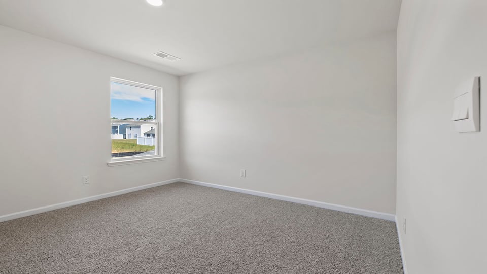Bedroom with window and carpet.