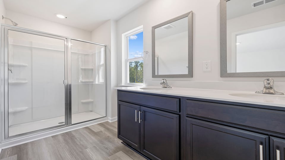 Primary bathroom with dual sink vanity and walk-in shower.