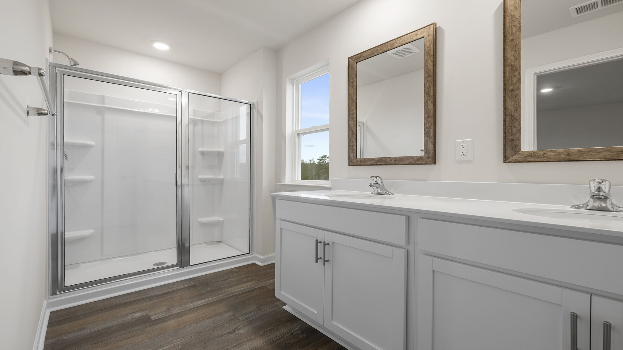 Primary bathroom with dual sink vanity and walk-in shower.