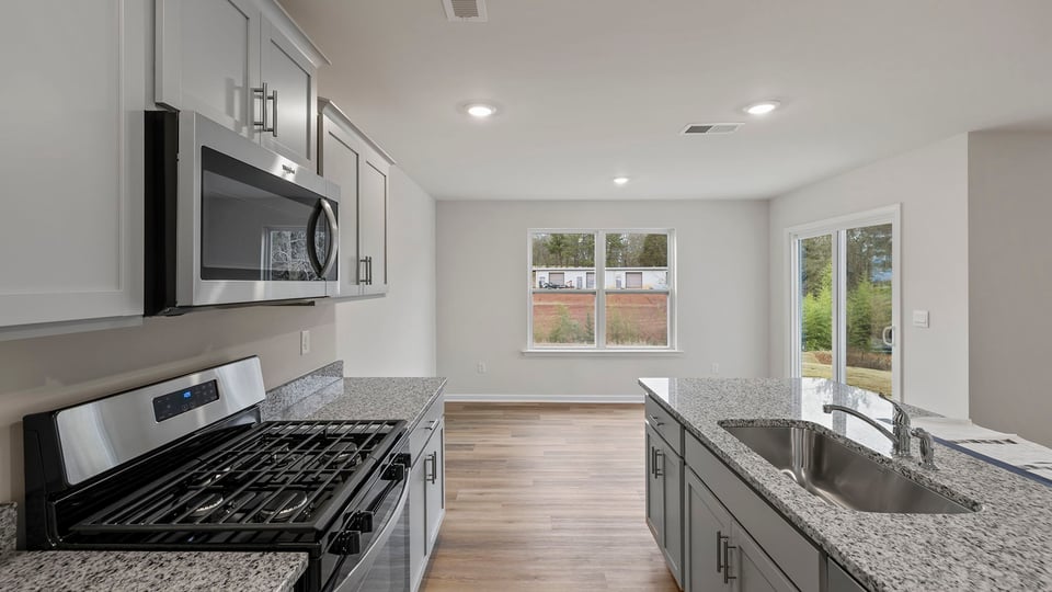 View of kitchen and dining area with receessed lighting.