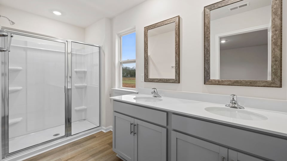 Primary bath with dual sink vanity and walk-in shower.
