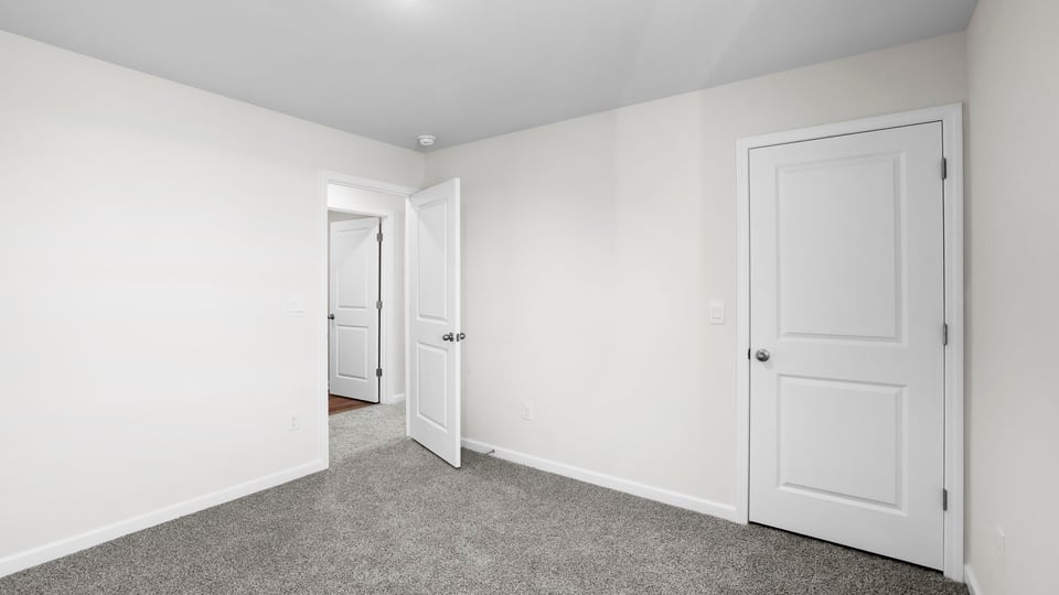 Bedroom with carpet and window.