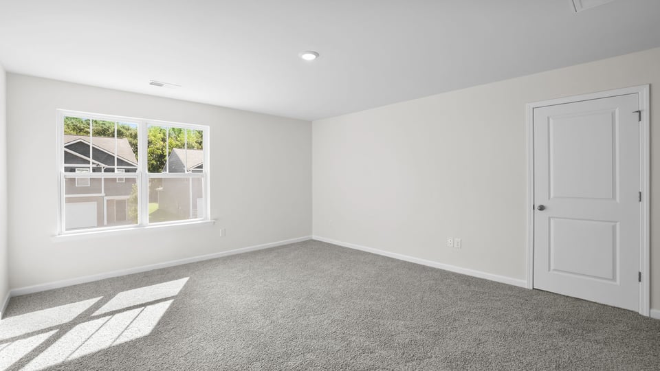 Bedroom with carpet and window.