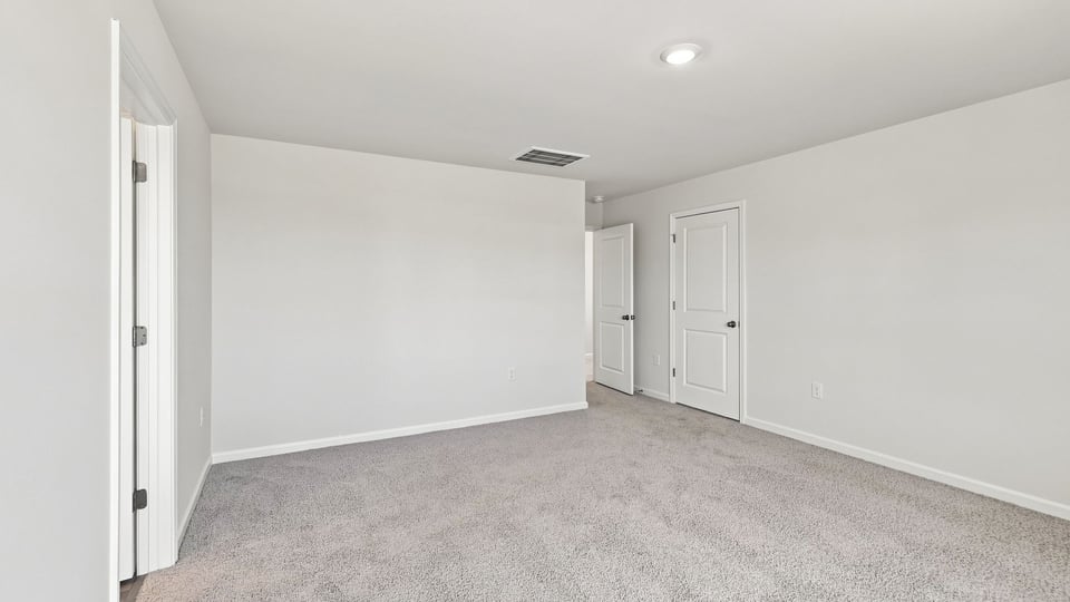 Bedroom with carpet and windows.