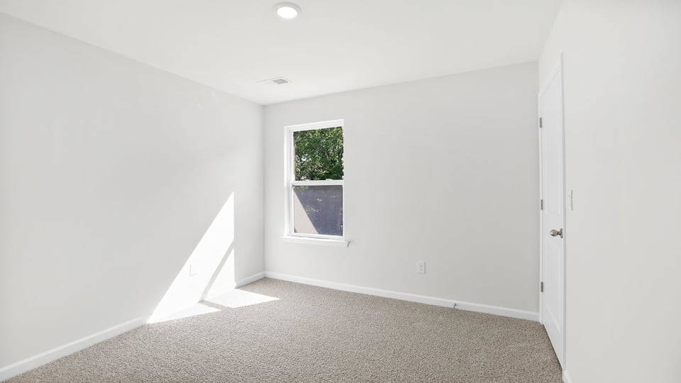 Bedroom with carpet and window.