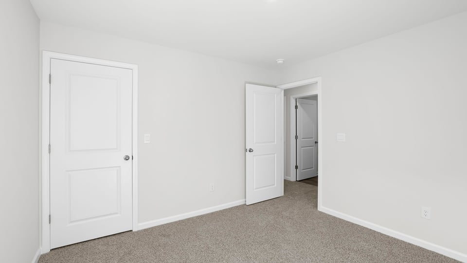 Bedroom with carpet and window.