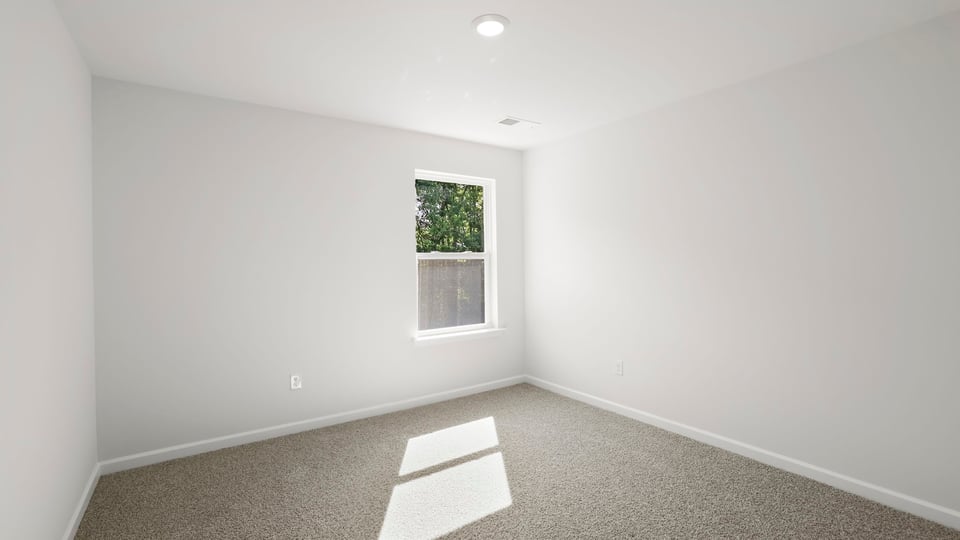 Bedroom with carpet and window.
