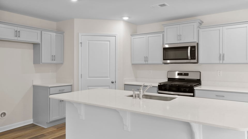 Kitchen with island and quartz countertops.