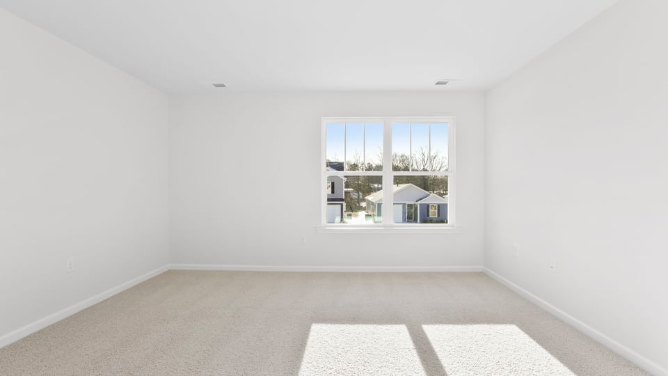 Primary bedroom with large window and carpet.