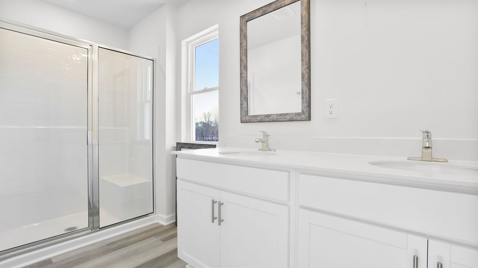 Primary bath with dual sink vanity and walk-in shower.