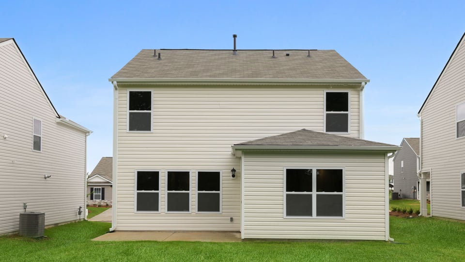 Back exterior of home with large backyard.