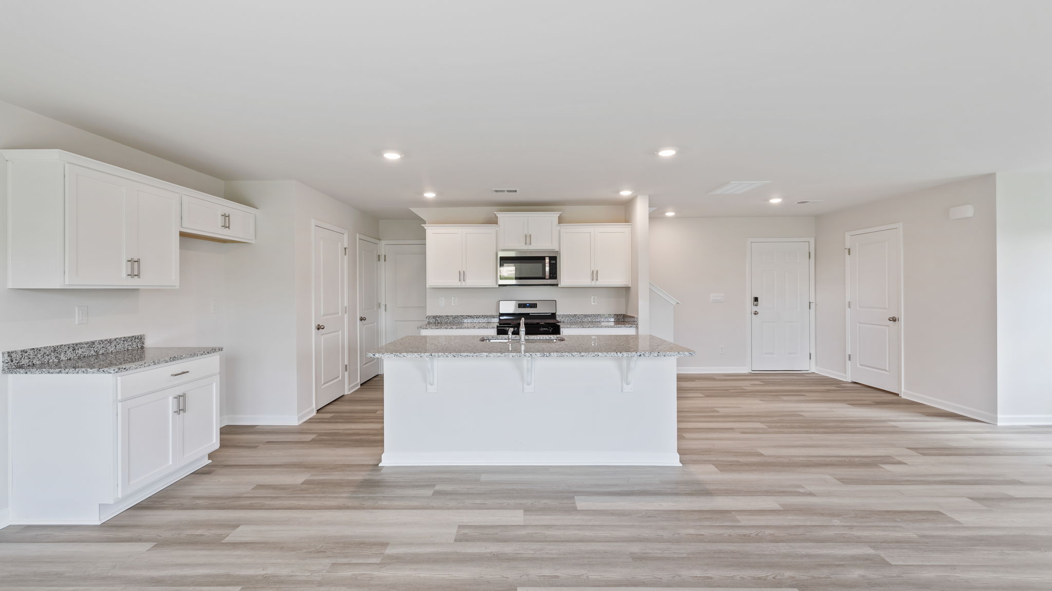 Open kitchen with island and recessed lighting.