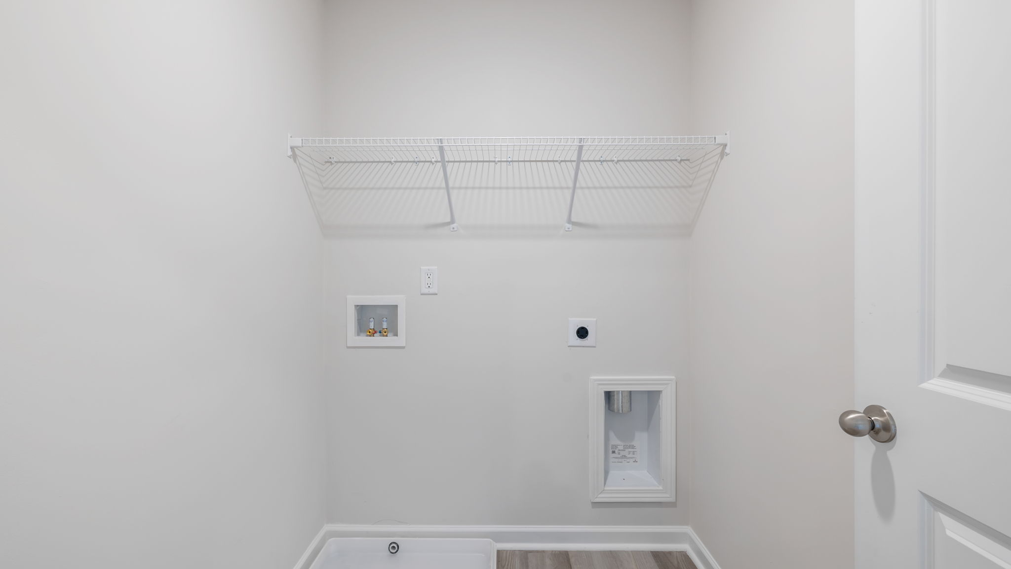 Walk-in laundry room with shelving.