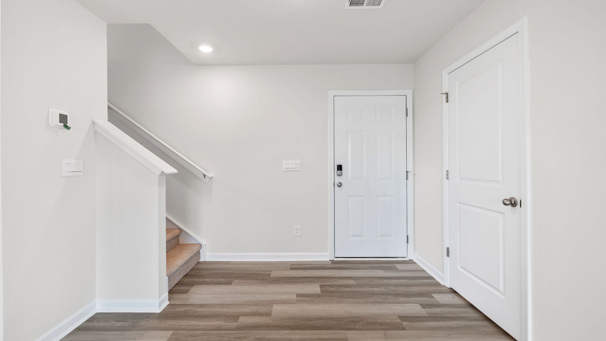View of entrance, foyer and stairwell to the upper level.