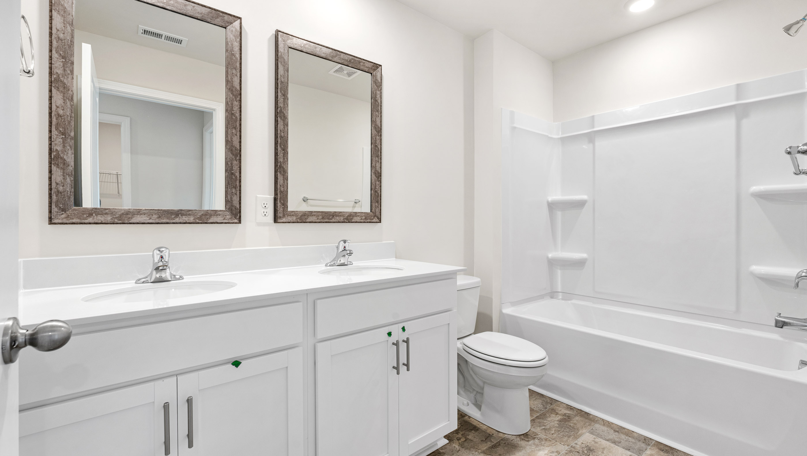 Bathroom with double vanity sink and tub.