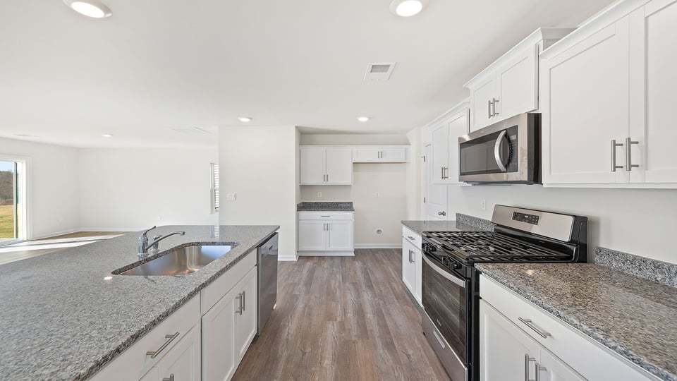 Kitchen with recessed lighting quartz countertops.