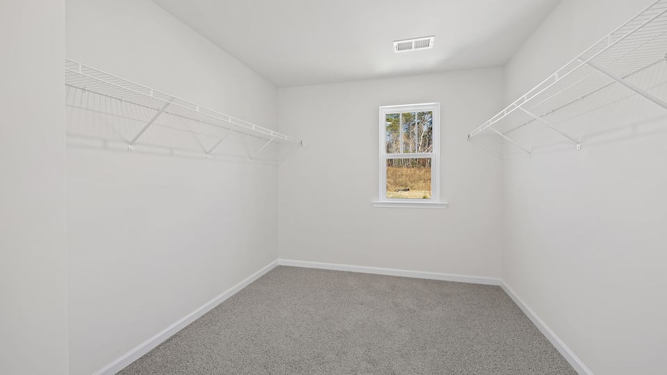 Primary bedroom walk-in closet with window.