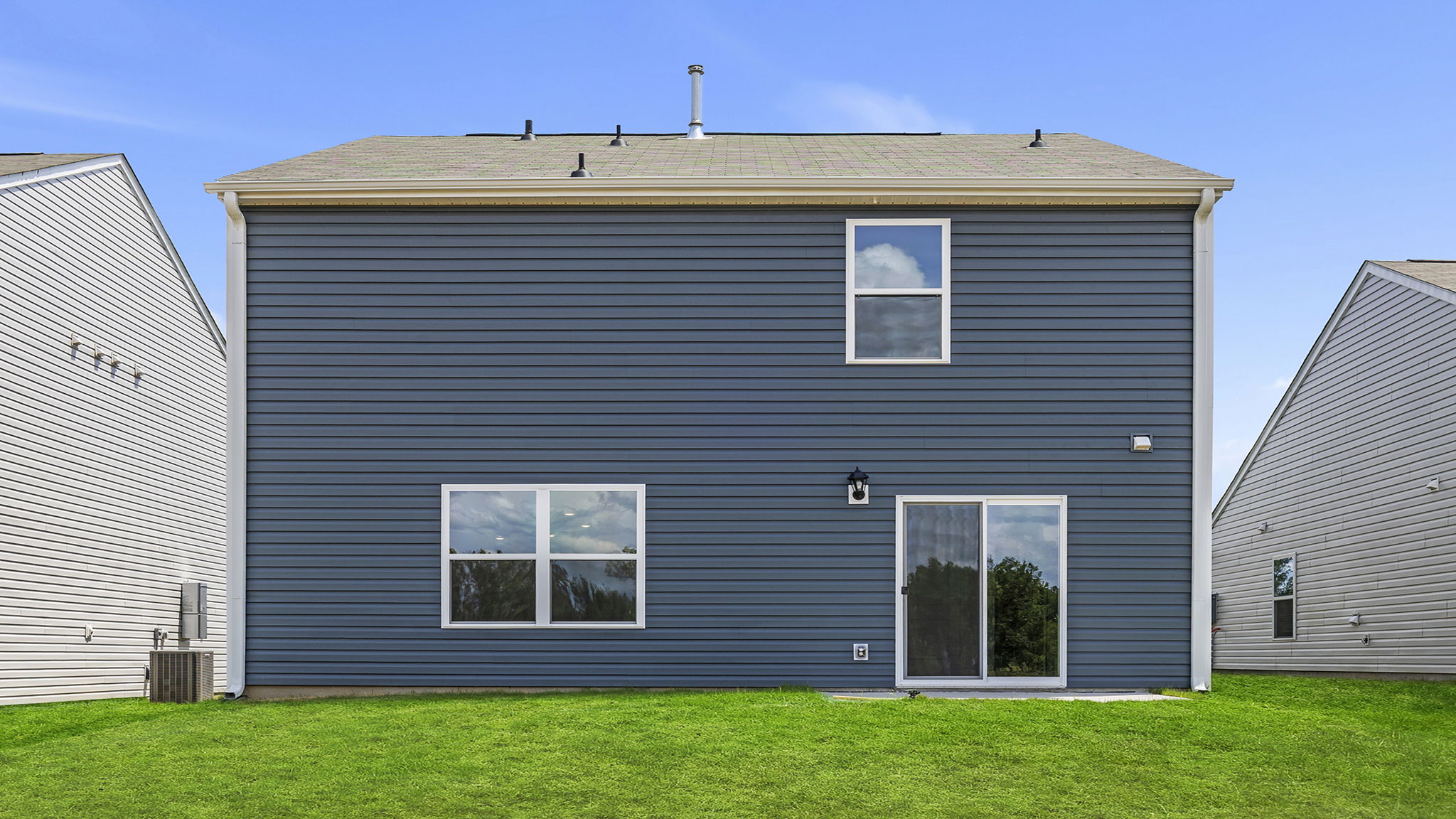 Back exterior of home with large backyard.