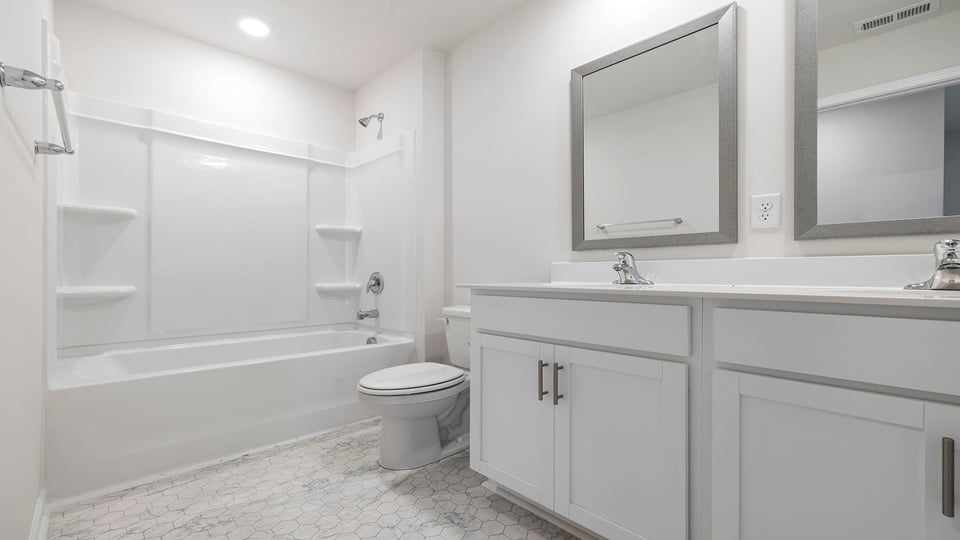 Hall bathroom with dual sink vanity with shower / tub.