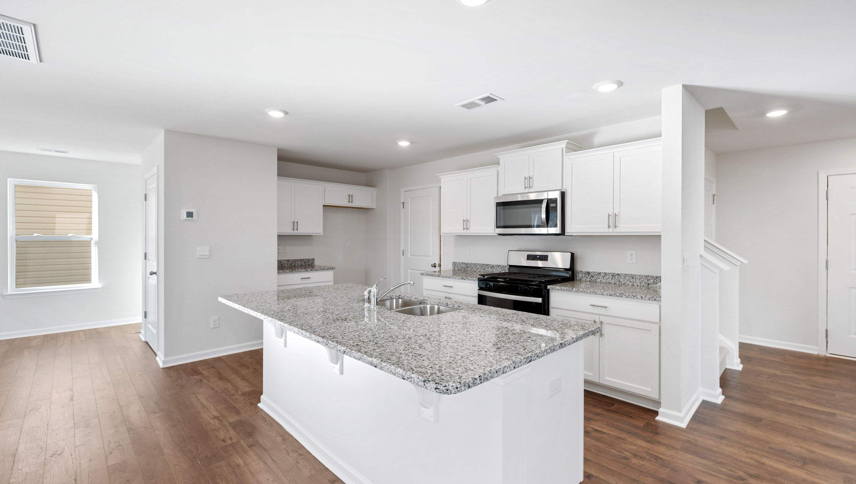 Kitchen and island with granite counter tops and stainless steel appliances.