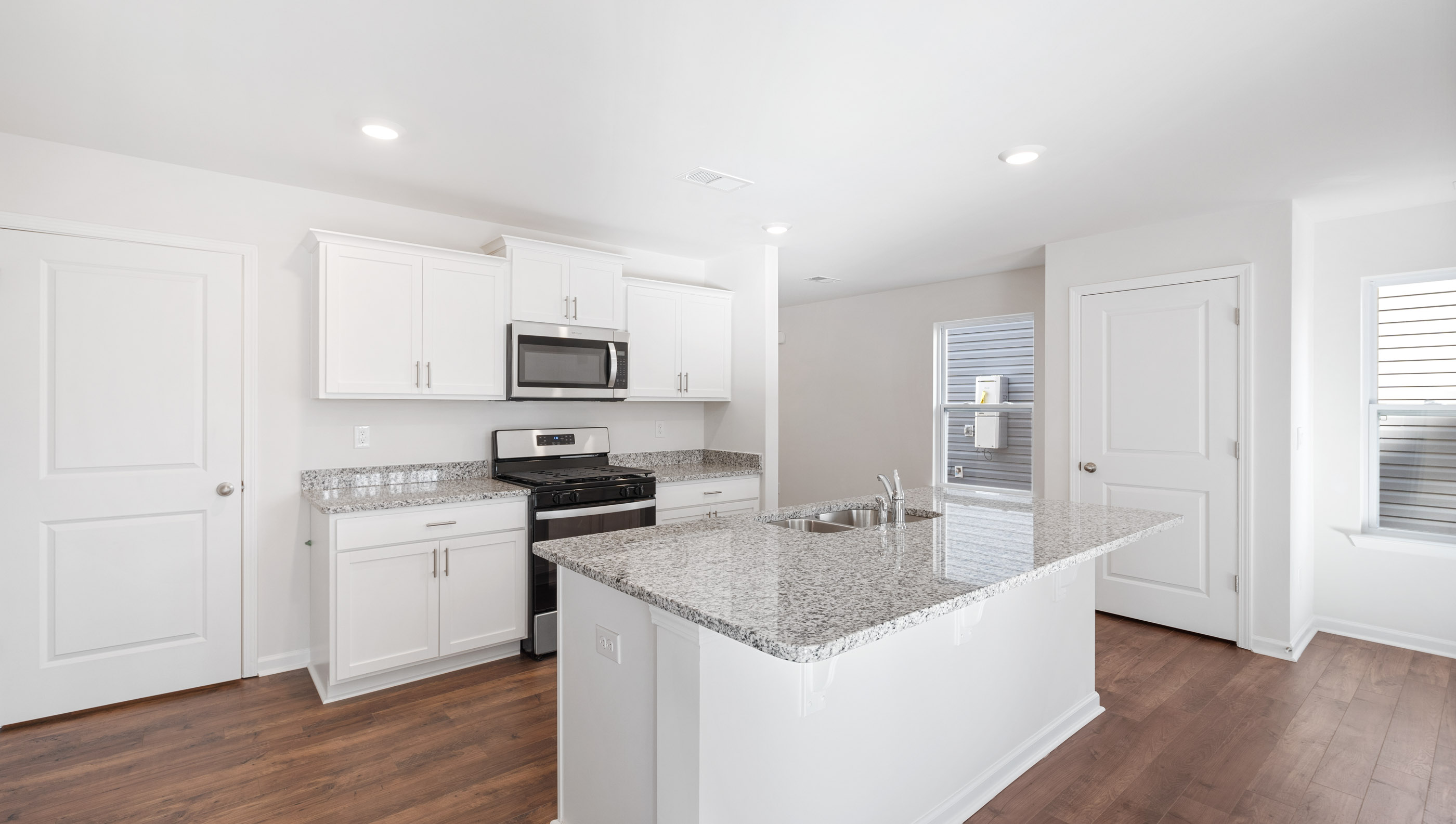 Kitchen and island with granite counter tops and stainless steel appliances.