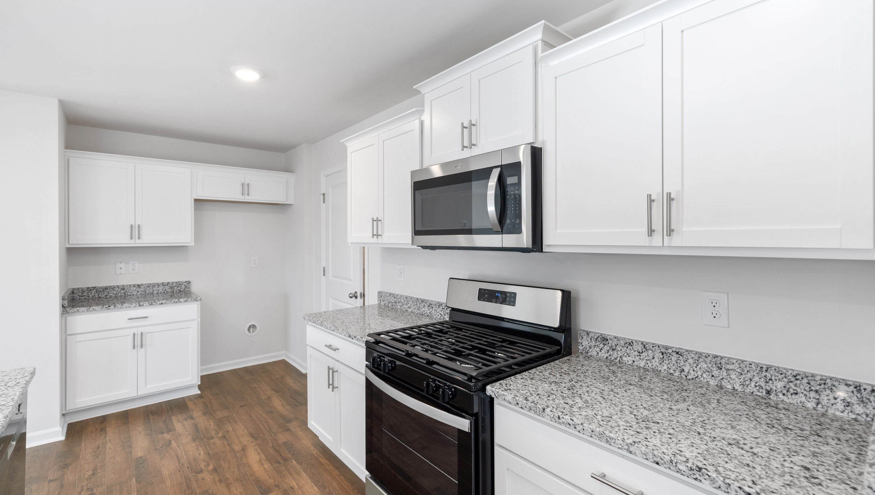 Kitchen and island with granite counter tops and stainless steel appliances.