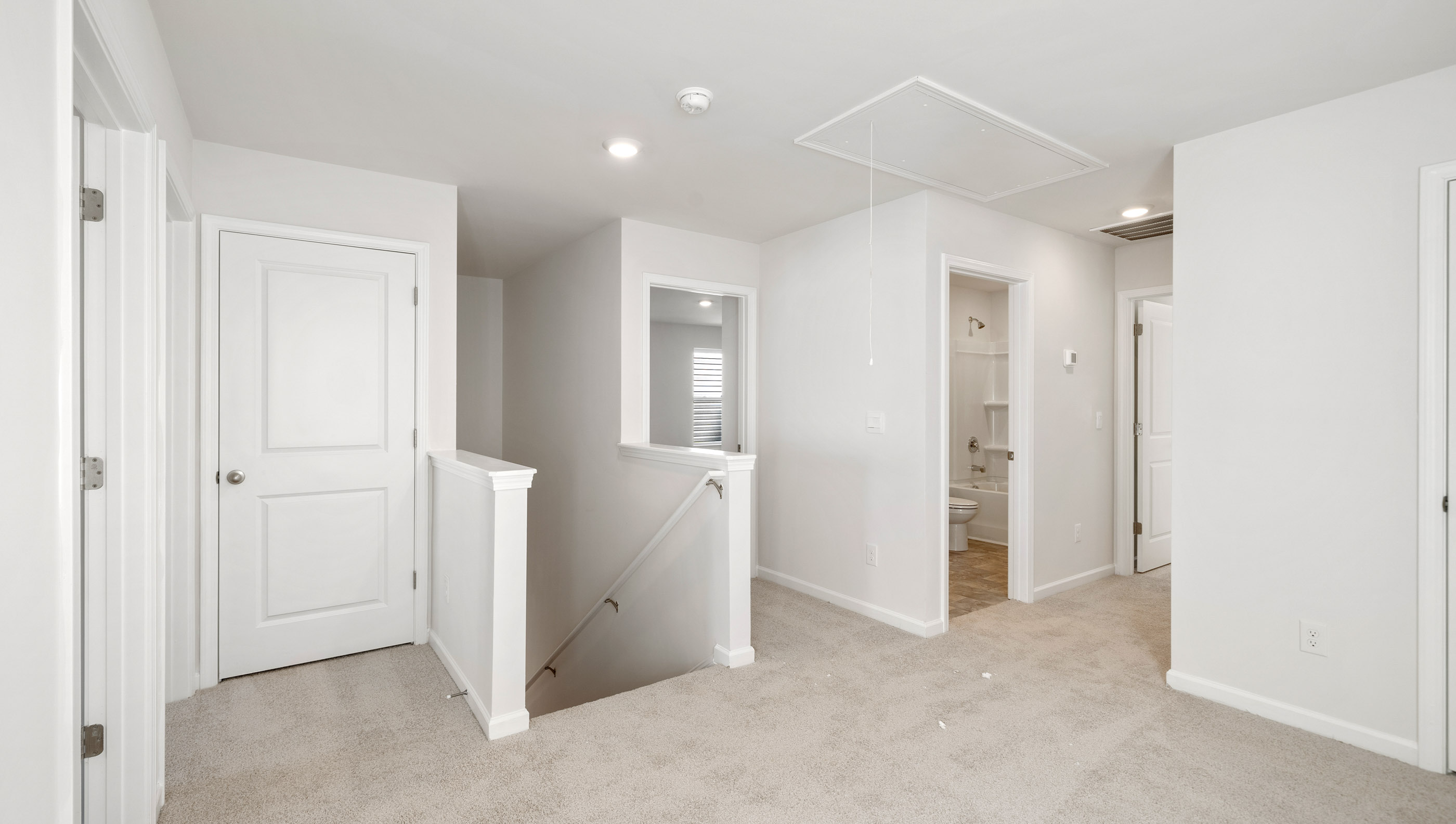 Loft area with carpet and windows.