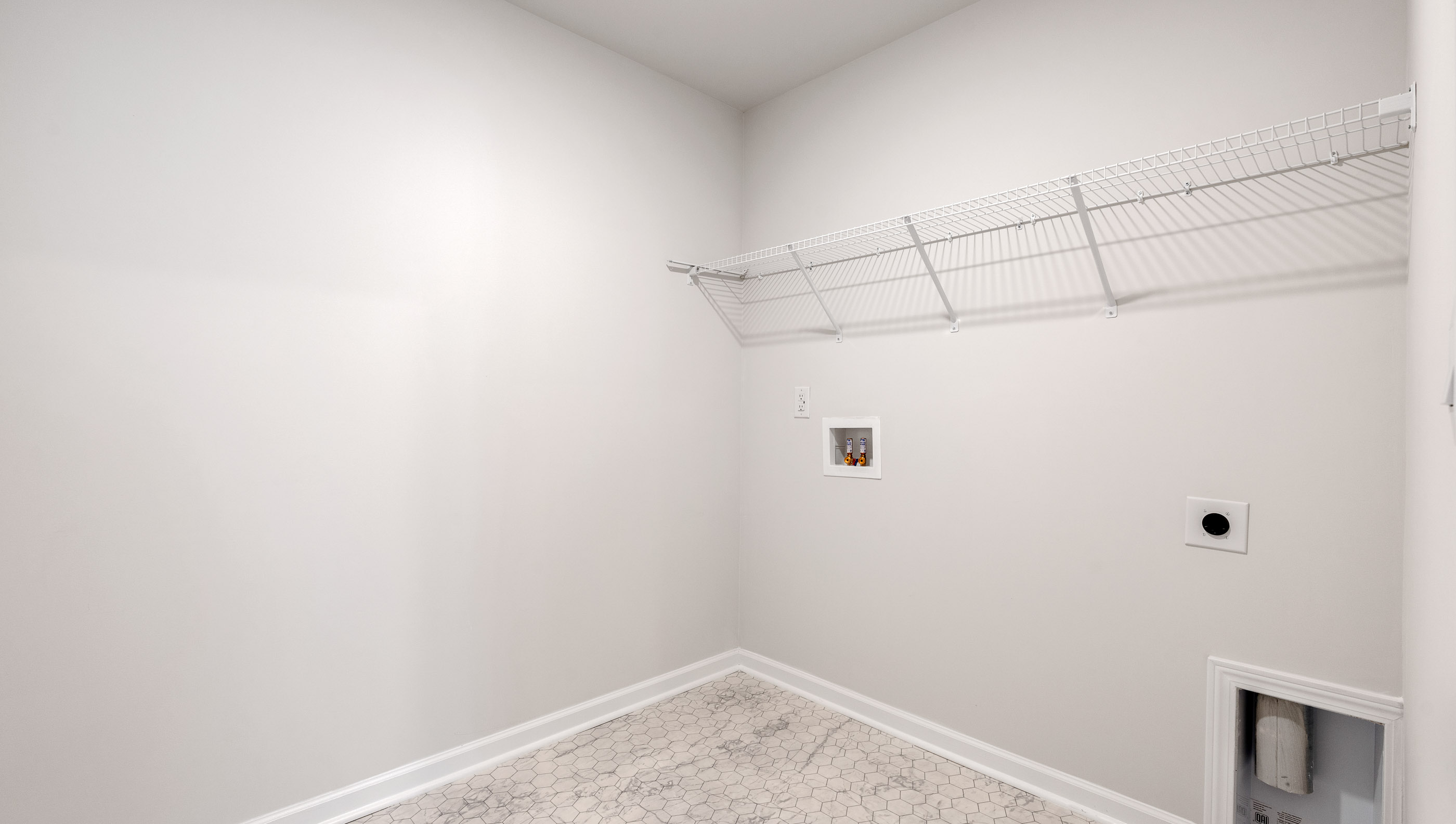 Walk-in laundry room with shelving.