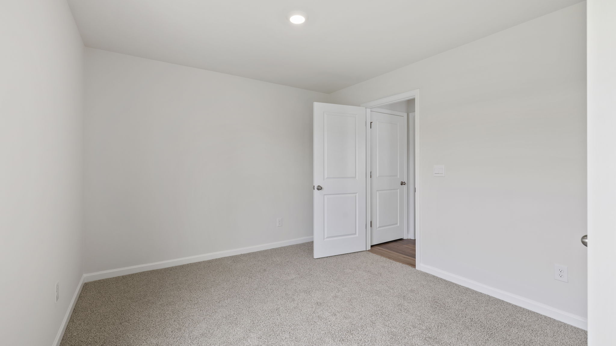 Bedroom on main level with carpet and window.