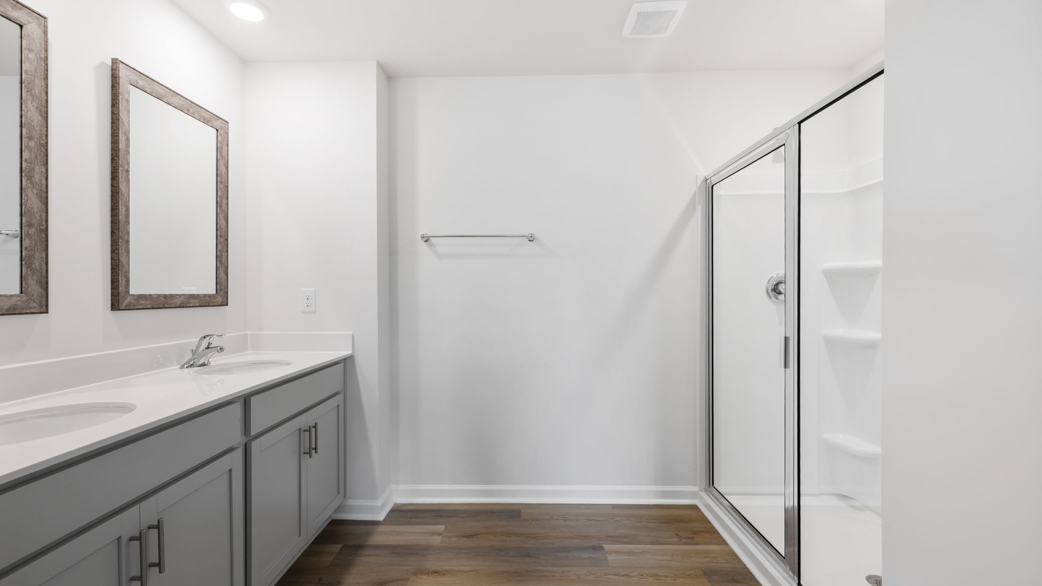 Primary bathroom with dual sink vanity and walk in shower.