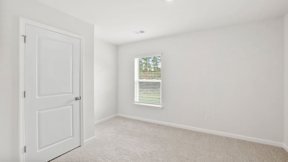 Bedroom with carpet and window.