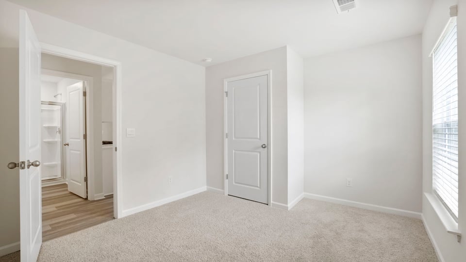 Bedroom with carpet and window.