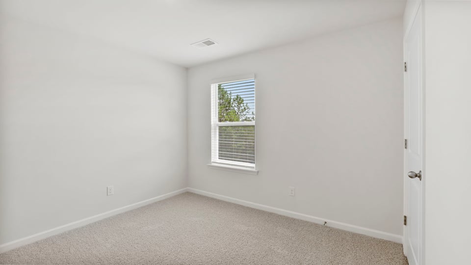 Bedroom with carpet and window.