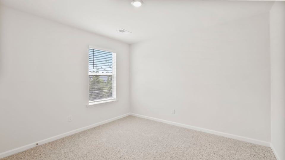 Bedroom with carpet and window.