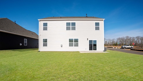 Back exterior of home with large backyard.