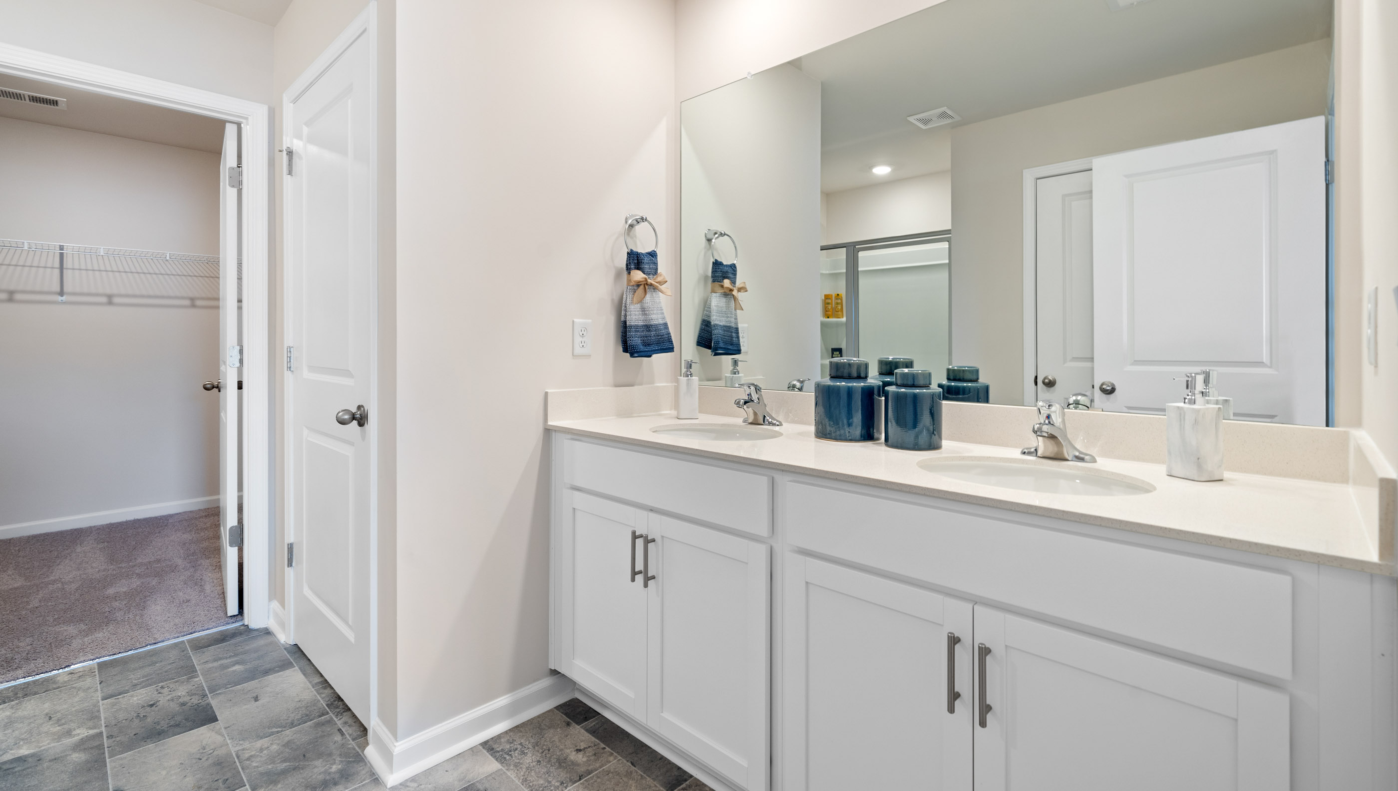 Bathroom with double vanity sink and closet.