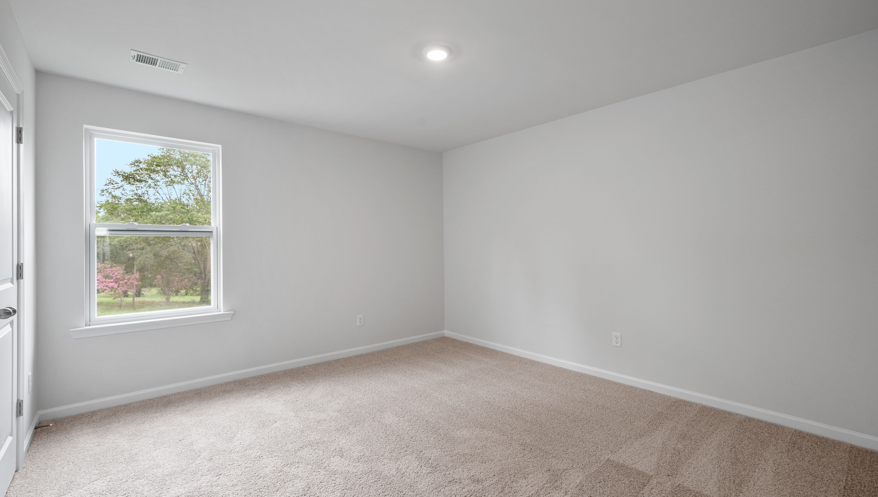 Bedroom with carpet and window.
