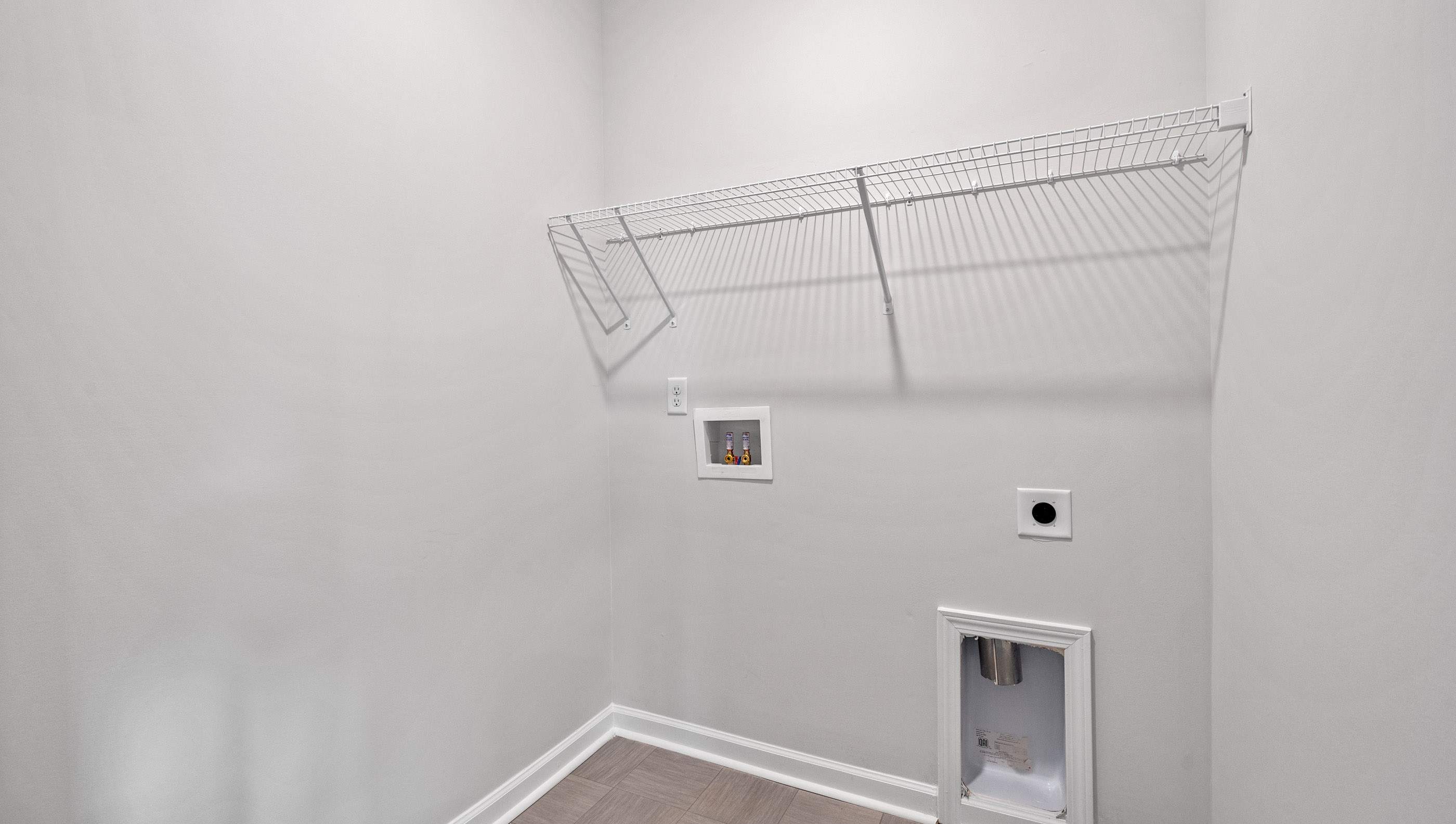 Laundry room with hanging storage racks.