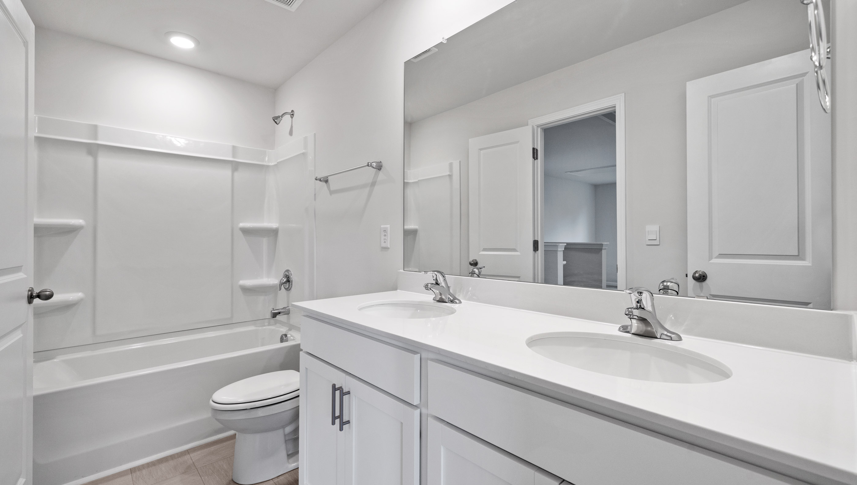 Bathroom with double vanity sink and tub.