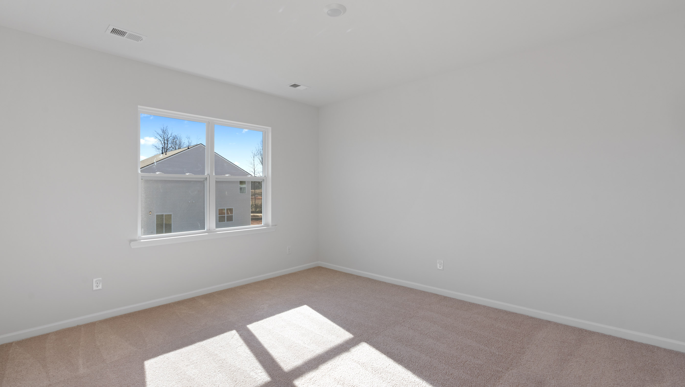 Bedroom with carpet and windows.