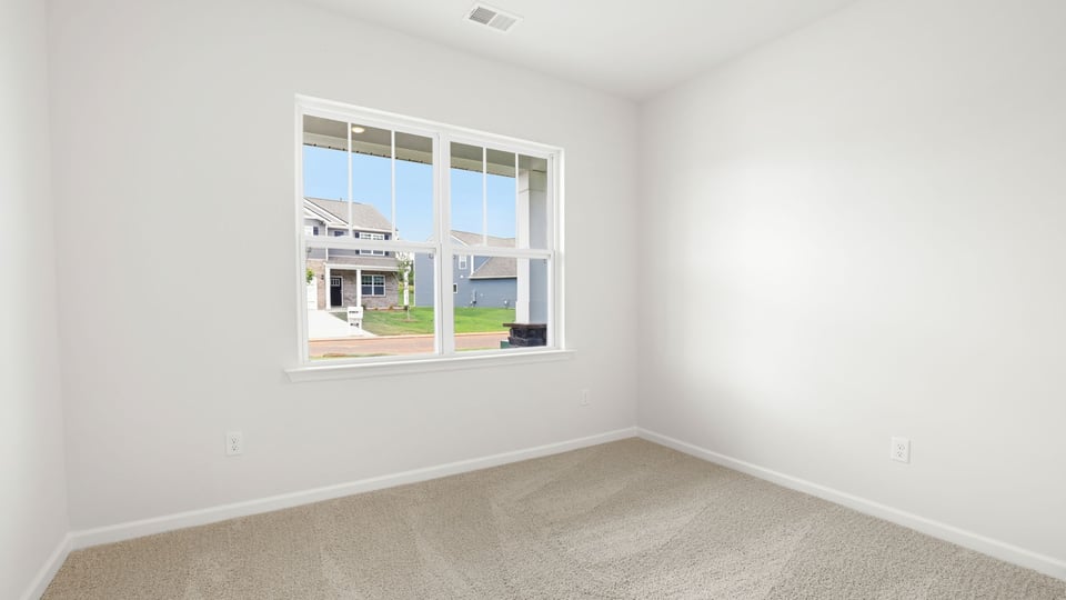 Bedroom with carpet and windows.