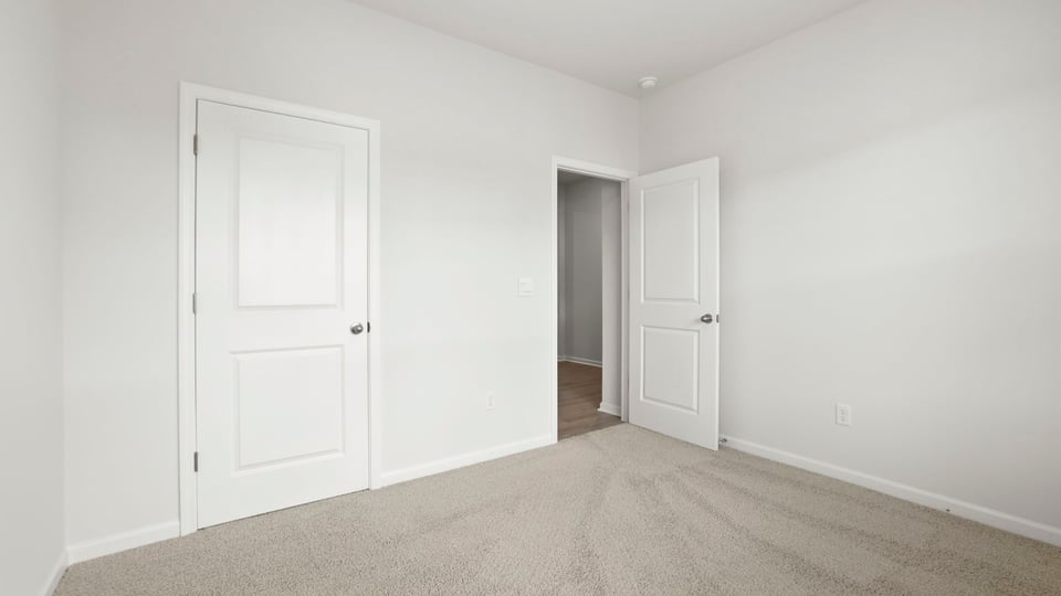 Bedroom with carpet and windows.